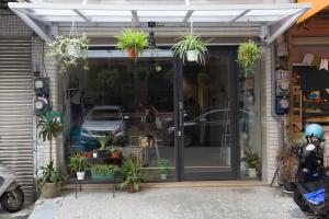 a store with potted plants on the front of it at KM Hostel in Chiayi City