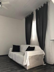 ポルト・サンテルピーディオにあるCasa Azzurraの白いベッド(窓の前に黒い枕付)
