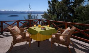 a table with two chairs and a table with food on it at Catalonia Sur Aparts-Spa in San Carlos de Bariloche