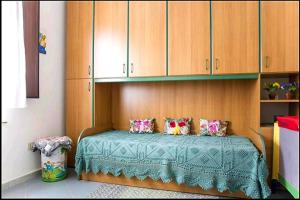 a bedroom with a bed with wooden cabinets at Appartamento Vacanza Barisardo SB in Bari Sardo