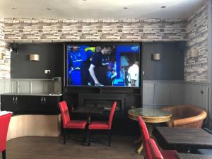 a bar with a tv and a table and chairs at The Old Black Horse Inn in Oxford