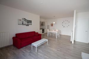 een woonkamer met een rode bank en een tafel bij Apartment Bolsena in Bolsena