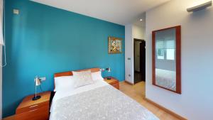 ビジャルバにあるPENSIÓN SUITES CAMIÑO NORTEの青いベッドルーム(ベッド1台、鏡付)