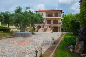 a large house with a stone driveway in front of it at Villa Anna in Nea Skioni