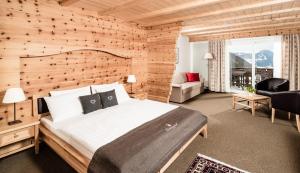 um quarto com uma cama grande e uma parede de madeira em Hotel Continental em Selva di Val Gardena