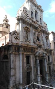 een oud stenen gebouw met een standbeeld erop bij B&B Santa Caterina in Palermo