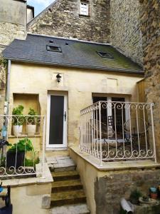 a stone house with a balcony and stairs at Chambre d´hote En Famille in Bayeux