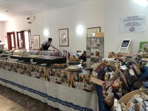 Hotel Riviera في ألغيرو: امرأة تحضر الطعام في بوفيه في متجر