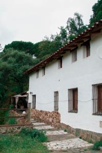 ein weißes Gebäude mit Seitenfenstern in der Unterkunft La Toscana in Linares de la Sierra