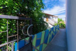 普拉的住宿－Homestay Pula，人行道旁的蓝色和绿色围栏