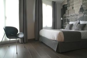 a bedroom with a bed and a chair and a window at Le Petit Boutique Hotel in Santander