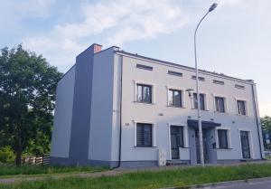 biały budynek po stronie ulicy w obiekcie Apartamenty Polna w Ostrowcu Świętokrzyskim