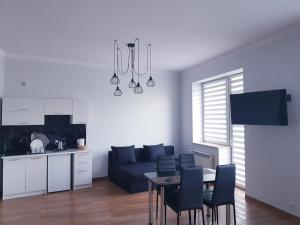 salon z kanapą i stołem z krzesłami w obiekcie Apartamenty Polna w Ostrowcu Świętokrzyskim
