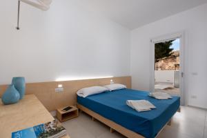 a bedroom with a blue bed and a window at Vitop Residence in San Vito lo Capo