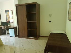 Cette chambre comprend un lit et une étagère. dans l'établissement Hotel & Residence La Sibilla Cusiana, à Pettenasco