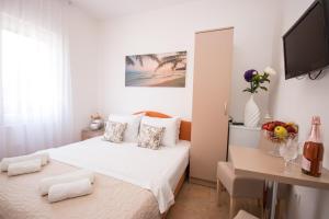 a white bedroom with a bed and a desk at Villa Kovacevic in Bar