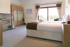 a large bedroom with a large bed and a fireplace at Bowood Park Hotel in Camelford