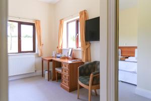 a room with a desk and a bedroom with a bed at Bowood Park Hotel in Camelford