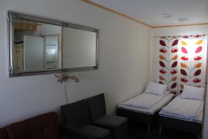 Habitación con 2 camas, espejo y silla. en Motel Willis West, en Ruka