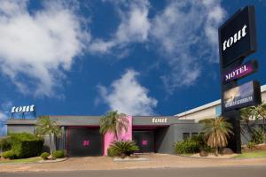 a front view of a store with palm trees in front at Tout Motel (Adults Only) in Campinas