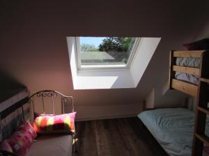 a attic room with a skylight and a bed and a window at Fisherman's cottage in Ile d'Arz