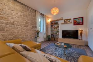 a living room with a couch and a tv at Apartment Oliveto Sibenik in Šibenik