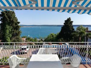 a table and chairs on a balcony with a view of the water at Apartments & Rooms Matos in Portorož
