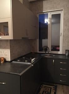 een keuken met een zwart aanrecht en een wastafel bij Guest House Kobuleti in Kobuleti