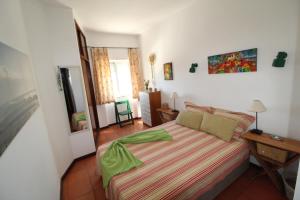 ポルティマンにあるApartamentoSolPraia - BeloHorizonteのベッドルーム1室(ベッド1台、緑の掛け布団付)