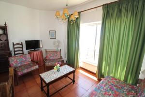 a living room with green curtains and a table and chairs at ApartamentoSolPraia - BeloHorizonte in Portimão +57 photos
