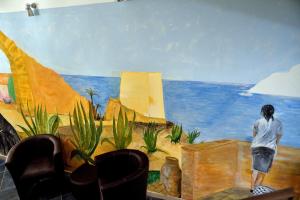 a person standing in front of a painting on a wall at B&B Dimora di Girgenti in Agrigento