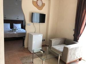 a bedroom with a bed and a chair and a tv at Dalyan Nehir suit hotel in Dalyan