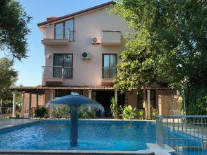 a house with an umbrella next to a swimming pool at Dalyan Nehir suit hotel in Dalyan