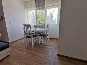 a dining room with a table and chairs and a window at Apartman MMS in Teslić +11 photos