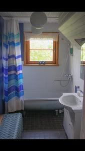 La salle de bains est pourvue d'une baignoire, d'un lavabo et d'une fenêtre. dans l'établissement Paadi puhkemaja, à Salinõmme