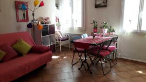 uma sala de estar com uma mesa e um sofá vermelho em Cosy Studio climatisé Vieux Nice proche mer et toutes commodités em Nice