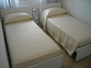 a small bedroom with two beds and a mirror at Grattacielo Royal Palace in Milano Marittima