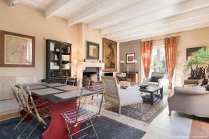 een woonkamer met een tafel en stoelen en een open haard bij Le Clos du Vieux Porche in La Couarde-sur-Mer