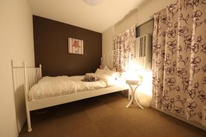 a bedroom with a white bed and a window at Casa HANA in Tokyo