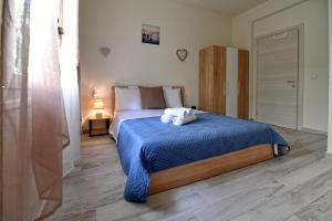 a bedroom with a bed with a blue comforter at Blue Sea Y in Kavála