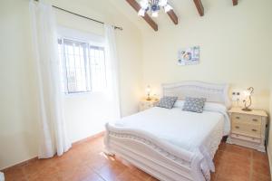 a white bedroom with a white bed and a window at Cubo's Finca de la Rosa in Alhaurín el Grande +19 photos
