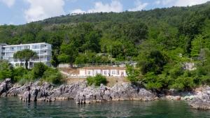 a building on the shore of a body of water at Boutique Hotel Acacia in Lovran
