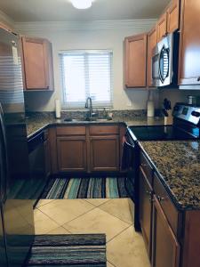 una cocina con armarios de madera y fregadero en Treasure Island Beach, FL Waterfront Condo, en St Pete Beach