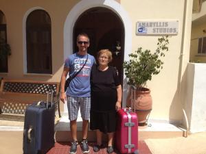 a man and a woman standing with their luggage at Amaryllis Hotel in Karpathos