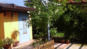 un albero di fronte a una casa con una recinzione di Lavanda e Rosmarino a Sandigliano