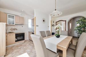 eine Küche und ein Esszimmer mit Tisch und Stühlen in der Unterkunft Apartment Ana in Brtonigla