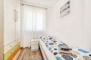 ein weißes Schlafzimmer mit einem Bett und einem Fenster in der Unterkunft Apartment Ana in Brtonigla + 20 Fotos