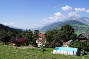 una casa con piscina in un campo con montagne di Bio-Bauernhof Greiml a Gröbming