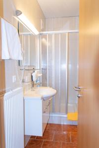 a bathroom with a sink and a shower at Strandhotel Burgstaller in Feld am See