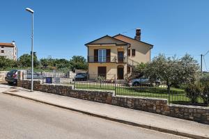 ein Haus an einer Steinmauer neben einer Straße in der Unterkunft Apartment Ana in Brtonigla